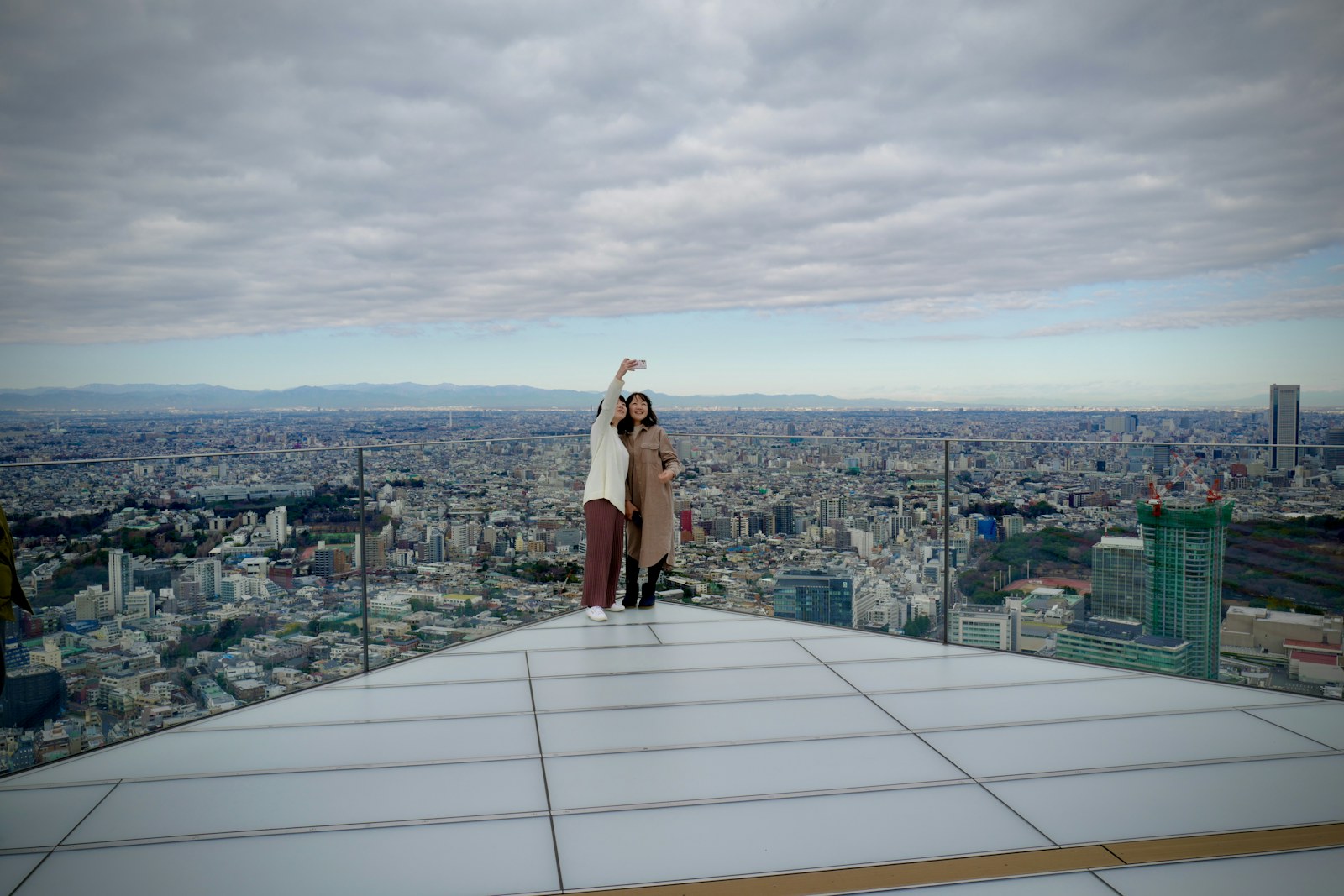 Visitors on the SHIBUYA SKY rooftop overlooking Tokyo