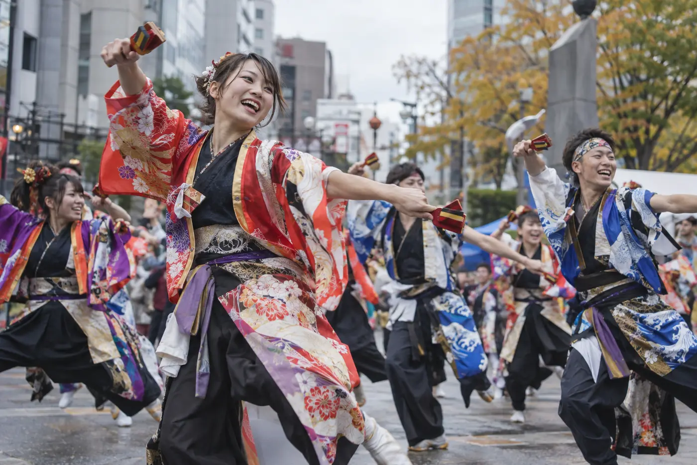 Yosakoi dancers in colorful costumes performing with clappers on a Tokyo street